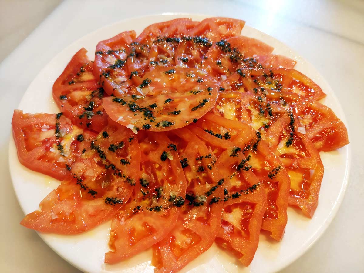 Sliced tomatoes seasoned with provencal herbs olive-oil